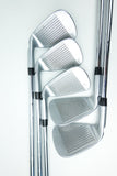 Four silver metal golf iron clubs arranged overlapping on a clean white background.