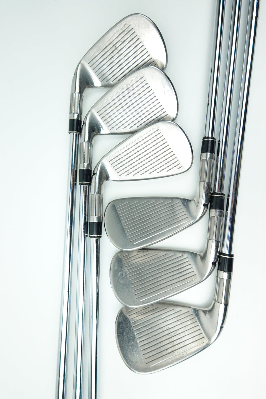 A set of five silver metal golf iron clubs arranged in a fan shape on a clean white background.