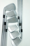 A set of five polished steel golf irons arranged in a fan pattern on a clean white background.