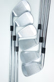 Five polished steel golf iron clubs arranged in a fan pattern on a clean white background.