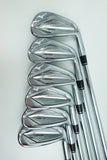 A set of seven polished steel golf irons arranged in a fan shape on a clean white background.