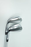 Two PING golf wedges with metallic silver and black clubs, positioned diagonally on a clean white background.