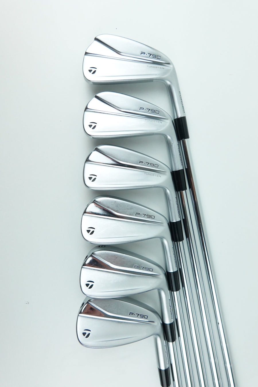Six TaylorMade golf iron clubs arranged in a fan shape on a clean white background.